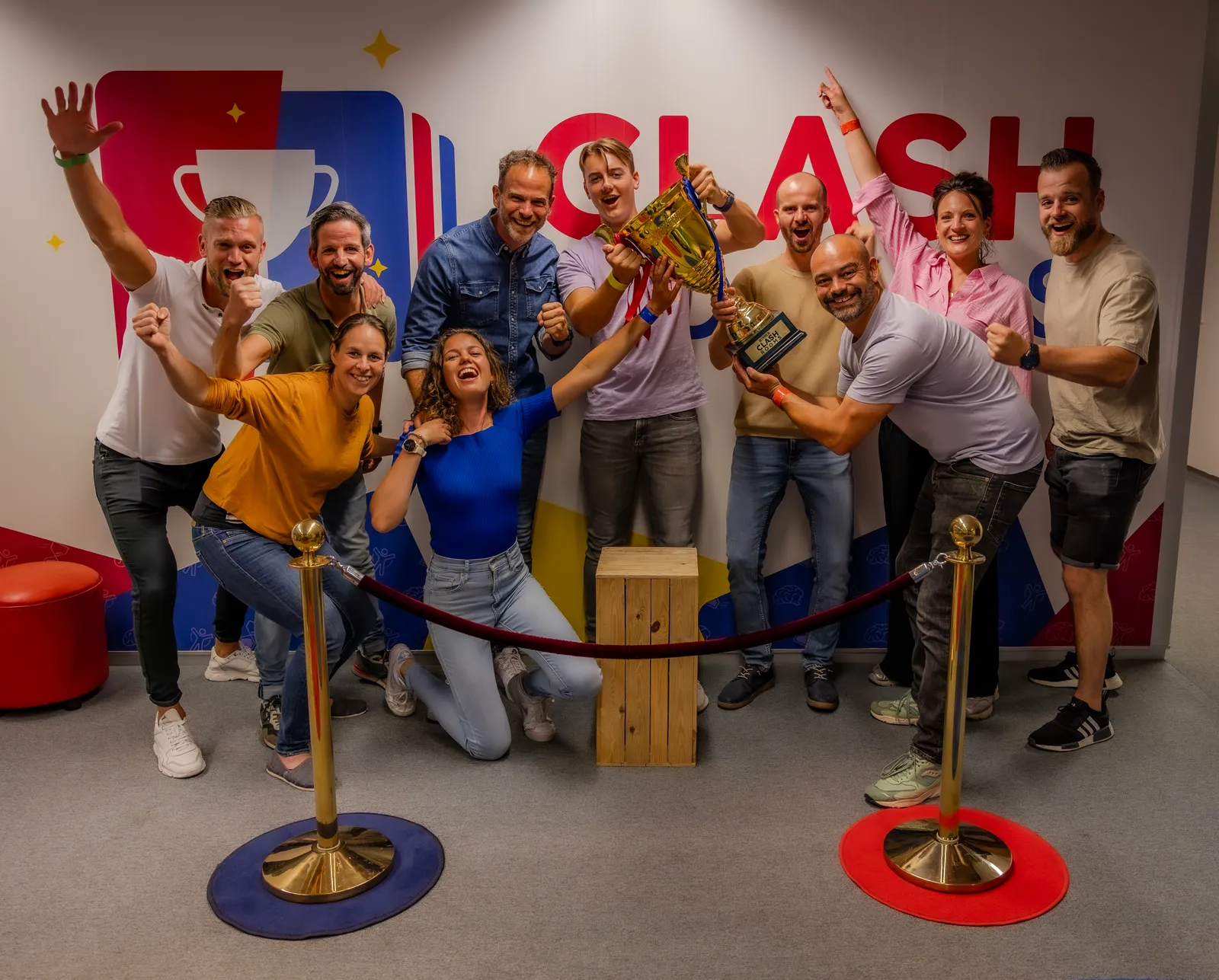 Groep mensen viert overwinning met trofee bij ClashRooms in Eindhoven